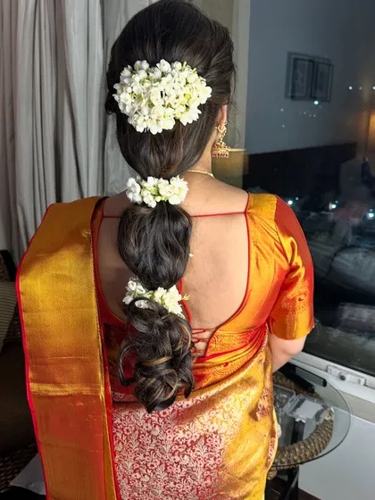 A view of the elegant braided hairstyle with fresh gajra, perfect for an engagement ceremony.