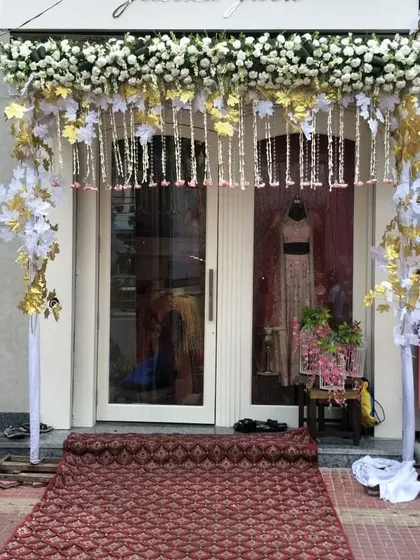 For the opening of a new boutique, we created this elegant entrance arch using a classic white and gold theme. The design features fresh white flowers, golden leaf accents, and hanging floral strings to welcome customers in style.