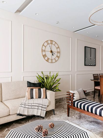 A comfortable, neutral-toned sofa is the perfect canvas for layering textures and patterns. Here, a mix of striped and woven cushions and a soft throw blanket make the seating area feel extra cozy and inviting.