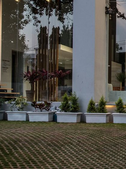 The entrance to this showroom uses grass pavers and linear planters to create a green welcome, blurring the line between the parking area and the building itself.