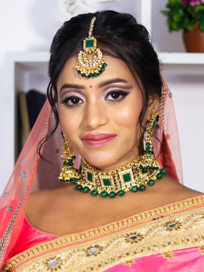 Another portrait of my elegant reception bride. The makeup is designed to enhance her features and complement the traditional jewelry and bright pink saree.
