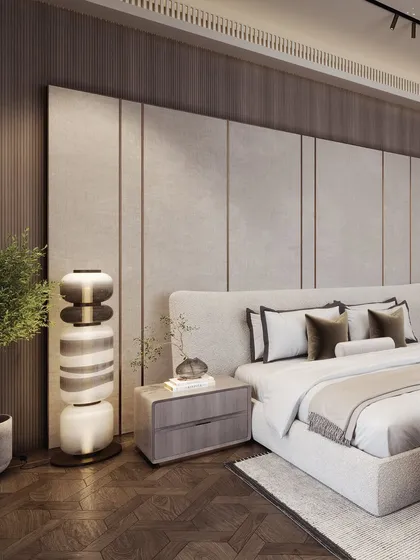 This view highlights the sculptural bedside lamp and the layered textures of the wall panels.
