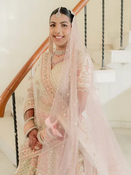 A happy, smiling Nidhi on her wedding day. The soft, dewy makeup enhances her natural glow, making her look and feel her absolute best.