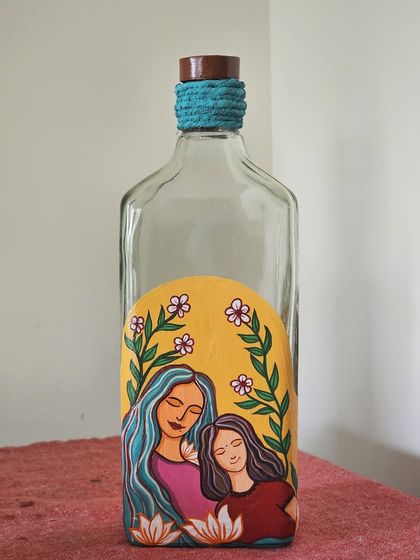 This bottle, featuring a mother and daughter, was painted by a participant in our 'Celebrating Motherhood' online workshop. The design includes a beautiful floral arch.