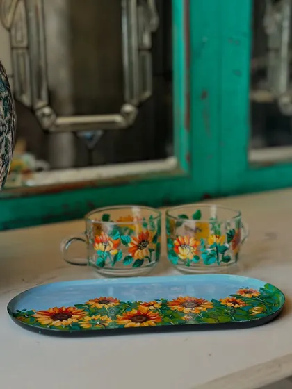 A set of our popular sunflower-themed tea cups and a matching tray, perfect for serving snacks and drinks.