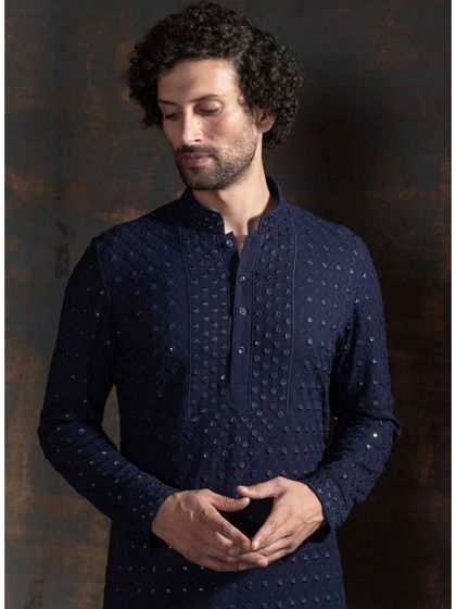 A luxurious navy blue kurta with intricate, shimmering embroidery. This piece is designed for a regal touch, perfect for a wedding reception or a grand festive event.