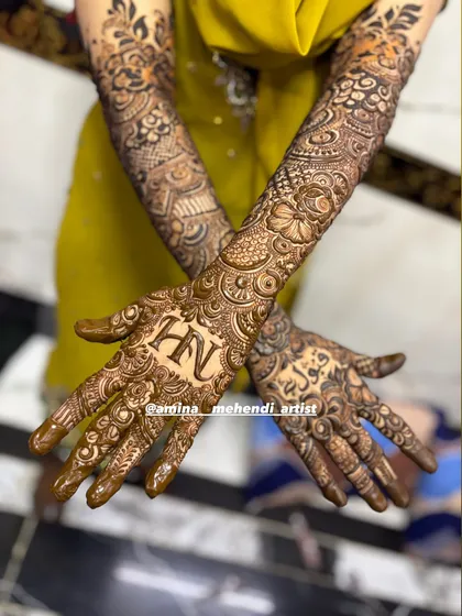 This design features the initials 'H' and 'N' on one palm and the name 'Fawad' in Arabic on the other.
