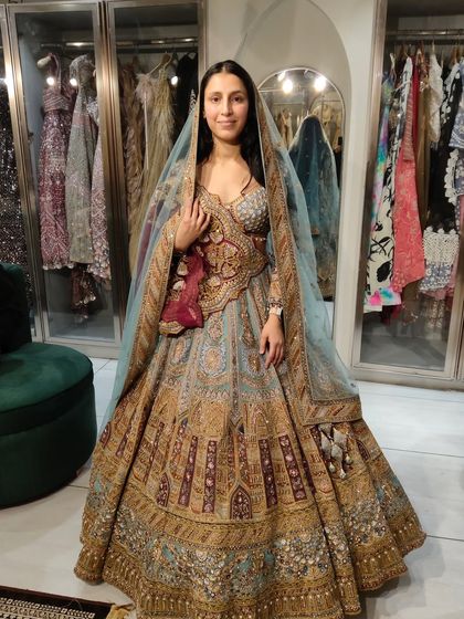 A sneak peek from the fitting room. This bride looks absolutely regal in a pastel blue and gold lehenga with a contrasting maroon velvet dupatta.