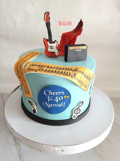 Rocking into his 40s! This custom guitar-themed cake was a surprise from a loving wife to her husband. This no-fondant cake features edible music notes, a Marshall amplifier, and sheet music, perfect for a true music lover.