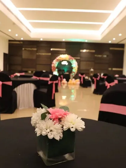 The party's seating arrangement, showing how the color theme was extended to the table decor with pink sashes on black chair covers.