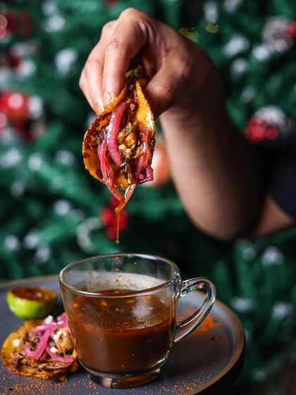 The festive season is upon us. Here, a guest enjoys our Birria-style tacos, dipping it into a rich, flavourful consommé.