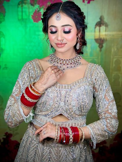 A soft and romantic look for a reception or engagement. The silver-grey lehenga is paired with pink-toned makeup and a classic red lip.