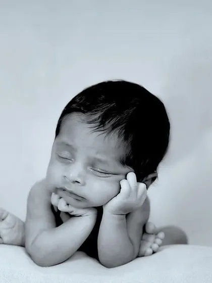 So tiny, so perfect. This classic black and white newborn portrait focuses on the delicate features and peaceful sleep of a brand new baby, a memory to cherish forever.