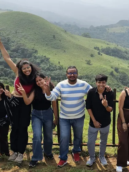 Fun and playful poses with the rolling green hills of Coorg as the backdrop. Our trips are filled with laughter and good times.