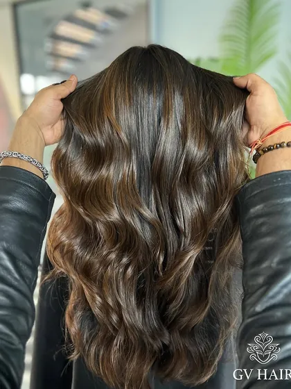 Shaping hair, shaping confidence. This glossy, dark brown with soft waves is pure elegance.