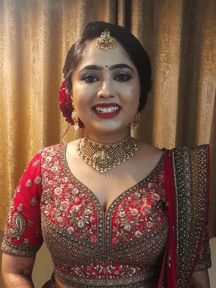 Our cute bride Aishwarya at her wedding reception. She chose a classic temple choker that looks beautiful with her embroidered red lehenga.