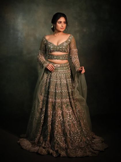 Another full-length shot of the green lehenga, showcasing its beautiful flare and intricate embroidery.