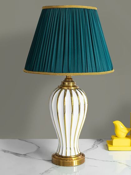 This lamp is a study in classic elegance with a modern twist. The white ceramic base with vertical gold stripes is paired with a rich, pleated teal shade, creating a sophisticated look for a desk or side table.
