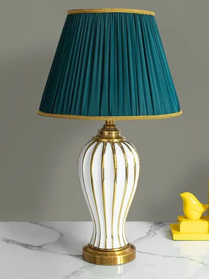 This lamp is a study in classic elegance with a modern twist. The white ceramic base with vertical gold stripes is paired with a rich, pleated teal shade, creating a sophisticated look for a desk or side table.
