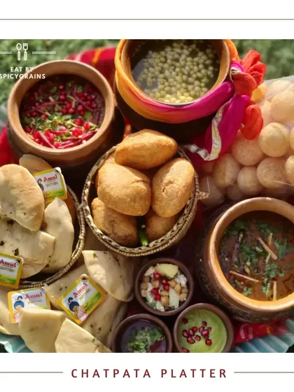 The ultimate Chatpata Platter, designed for lovers of tangy and spicy Indian street food. This platter is loaded with favorites like chole bhature, golgappe, and dahi bhalla, garnished with pomegranate and fresh herbs.