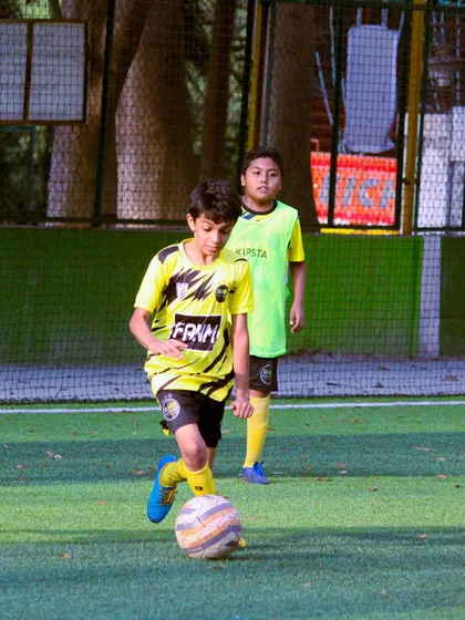 A player dribbles with his head up, scanning the field for options, a key aspect of game intelligence.