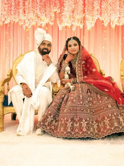 A classic portrait of the bride and groom seated, looking like royalty on their wedding day.