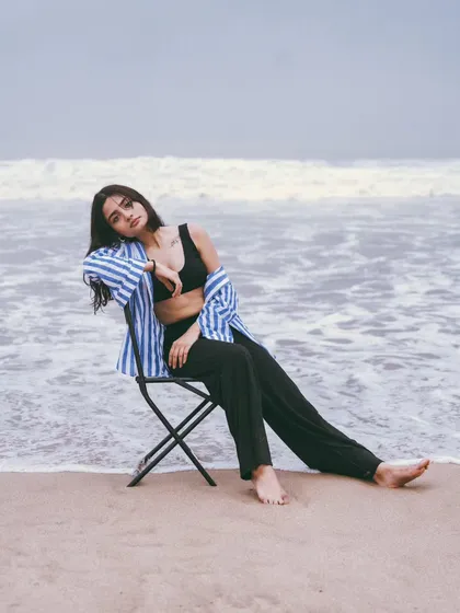 A relaxed, full-body pose on the chair, with the waves at her feet. This creates a story and a very editorial feel.