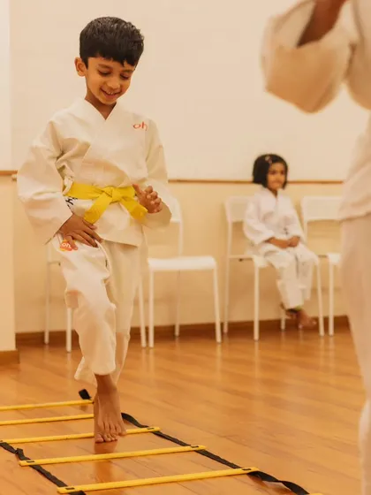 A young student practices his footwork on an agility ladder. Our karate classes incorporate drills that improve coordination, balance, and speed.