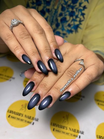 A deep and moody aura nail set. The black base fades into a smoky blue center, creating a mysterious and commanding look with a glossy finish.