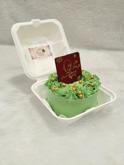 A vibrant green bento cake for Guruji's birthday, decorated with beautiful frosting roses and gold sprinkles.