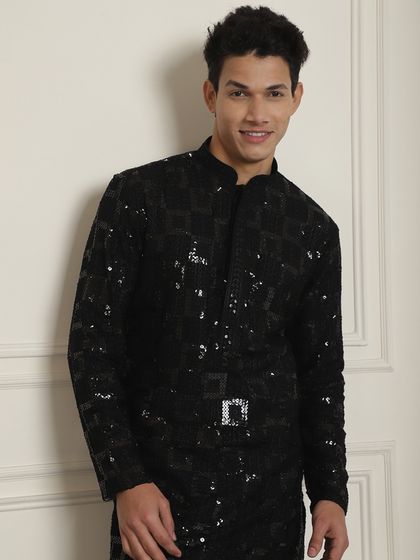 Black and its hues. A model smiles in a black sequined kurta, a look that is effortless yet high on style, perfect for a Sangeet night.