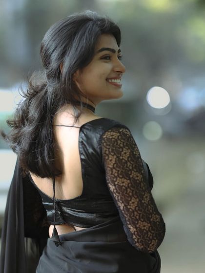 This shot highlights the back of the blouse and a side profile. The makeup remains flawless, with a soft contour and a natural smile, perfect for fashion or portrait photography.