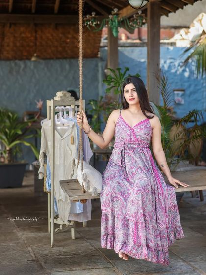 A collection of relaxed, bohemian-style portraits taken at a rustic cafe. The model is featured in a flowing paisley dress, interacting with props like a guitar, creating a natural and artistic vibe.