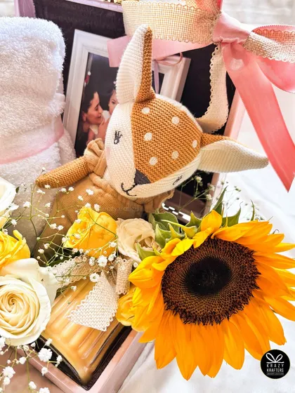 This view shows the entire composition of the hamper, with the fresh flowers, personalized items, and a scented candle, all curated to create a feeling of sunshine and warmth.