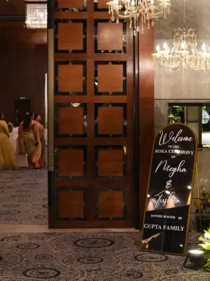 The grand entrance to Megha and Tushar's Roka, with stunning floral arrangements and a personalized welcome sign creating an inviting atmosphere.