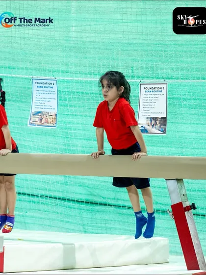 A young gymnast maintains her focus and posture on the balance beam. Our facility includes professional-grade equipment for all levels.