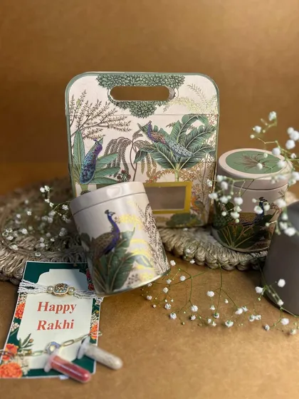 This Rakhi hamper, with its peacock-themed tin boxes and a beautiful Rakhi card, is inspired by the timeless bond of love and devotion. It’s a thoughtful way to honor your sibling.