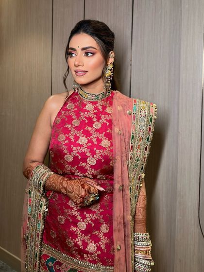 A full view of Tanvi's mehendi look. The pink eye makeup adds a touch of playfulness to the traditional outfit.