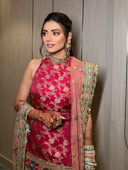 A full view of Tanvi's mehendi look. The pink eye makeup adds a touch of playfulness to the traditional outfit.