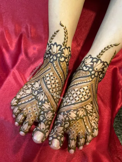 A lovely bridal foot design with delicate floral patterns and leafy vines extending up the ankle.