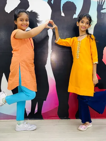 Two friends making a heart shape during our Independence Day celebrations, dressed in saffron and orange kurtas.