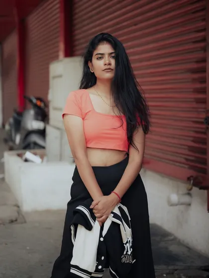 This is what Church Street style looks like. The model's casual outfit and direct gaze, set against the backdrop of red shutters, capture the authentic vibe of the city.