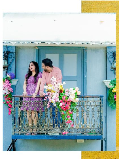 A colorful and vibrant pre-wedding shot of a couple on a decorated balcony.
