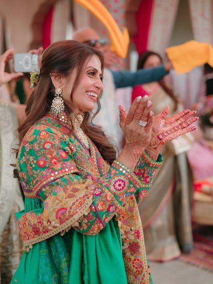 A candid, joyful shot of the mother of the bride. Her makeup is radiant and age-appropriate, ensuring she looks like the star she is.