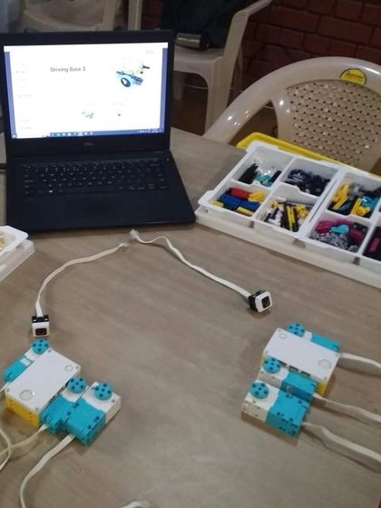 The building blocks of coding. A student connects motors and sensors to the LEGO Spike hub, preparing to write the code that will bring his creation to life.