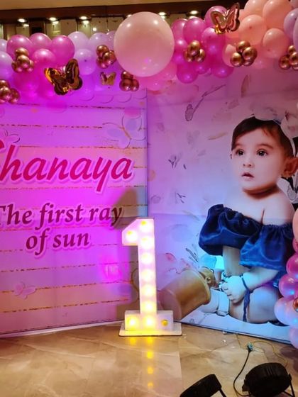 The butterfly photo backdrop illuminated with pink lighting, creating a warm and magical glow.