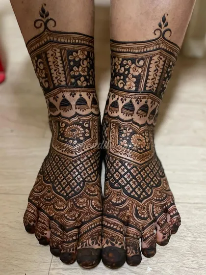 Bridal feet deserve just as much detail. This design features full coverage with intricate jharokha (window) patterns, jhumka motifs, and dense checkerboard filling that extends from the ankle to the toes.