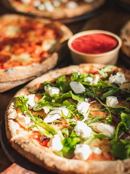 A duplicate image of the pizza spread, emphasizing the fresh, vibrant toppings and perfectly baked crusts that are ready for pairing.