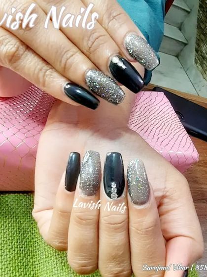 A bold combination of black and silver glitter on long coffin nails, with subtle rhinestone details.