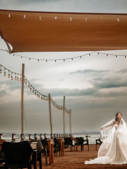 A beautiful bridal portrait on a pier, with the bride's veil catching the wind. The moody sky adds a dramatic touch.